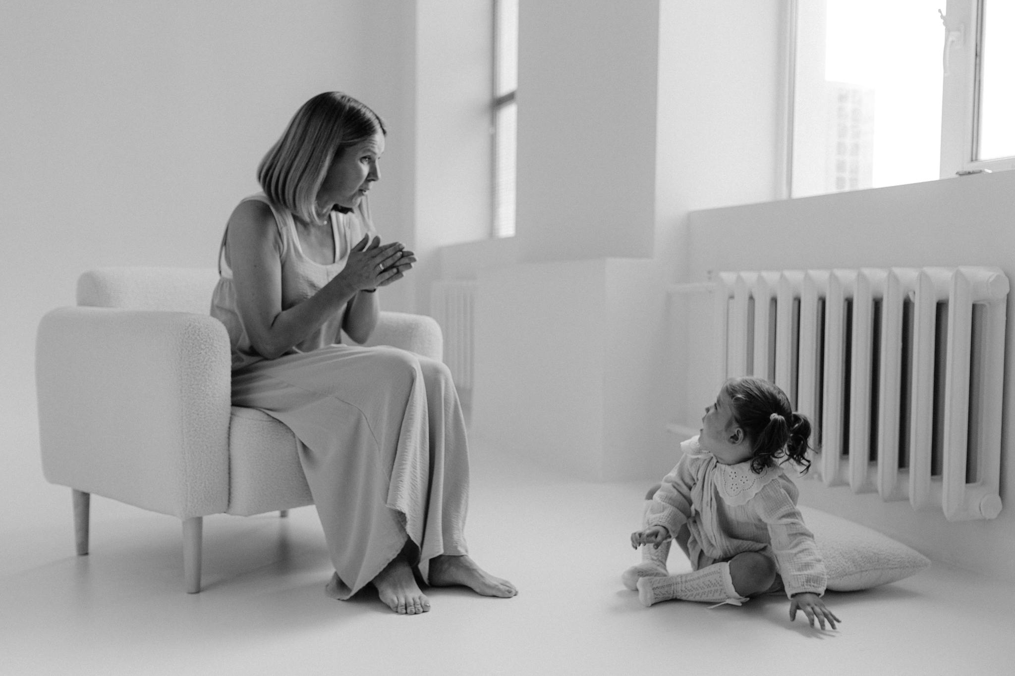 Black and white image of an adult and child in an interaction, emphasizing connection.